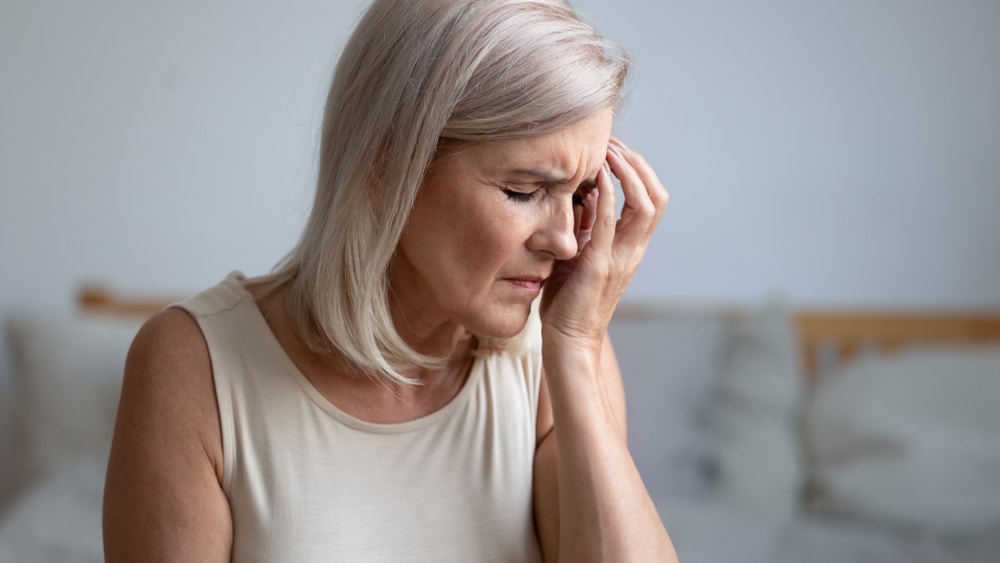 Stress older woman holding her head