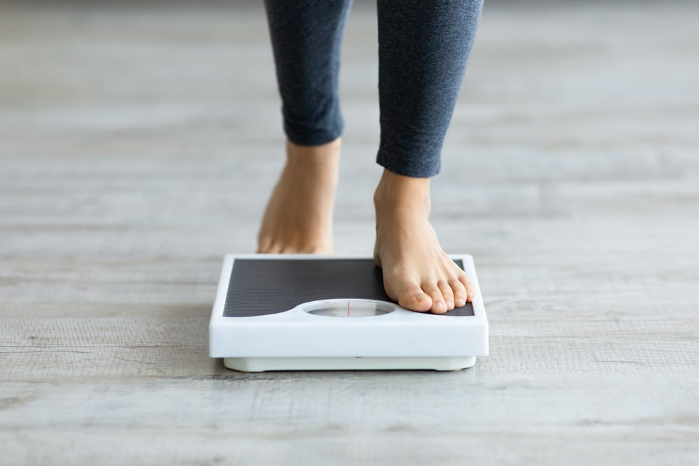 Woman stepping on a scale to weigh in